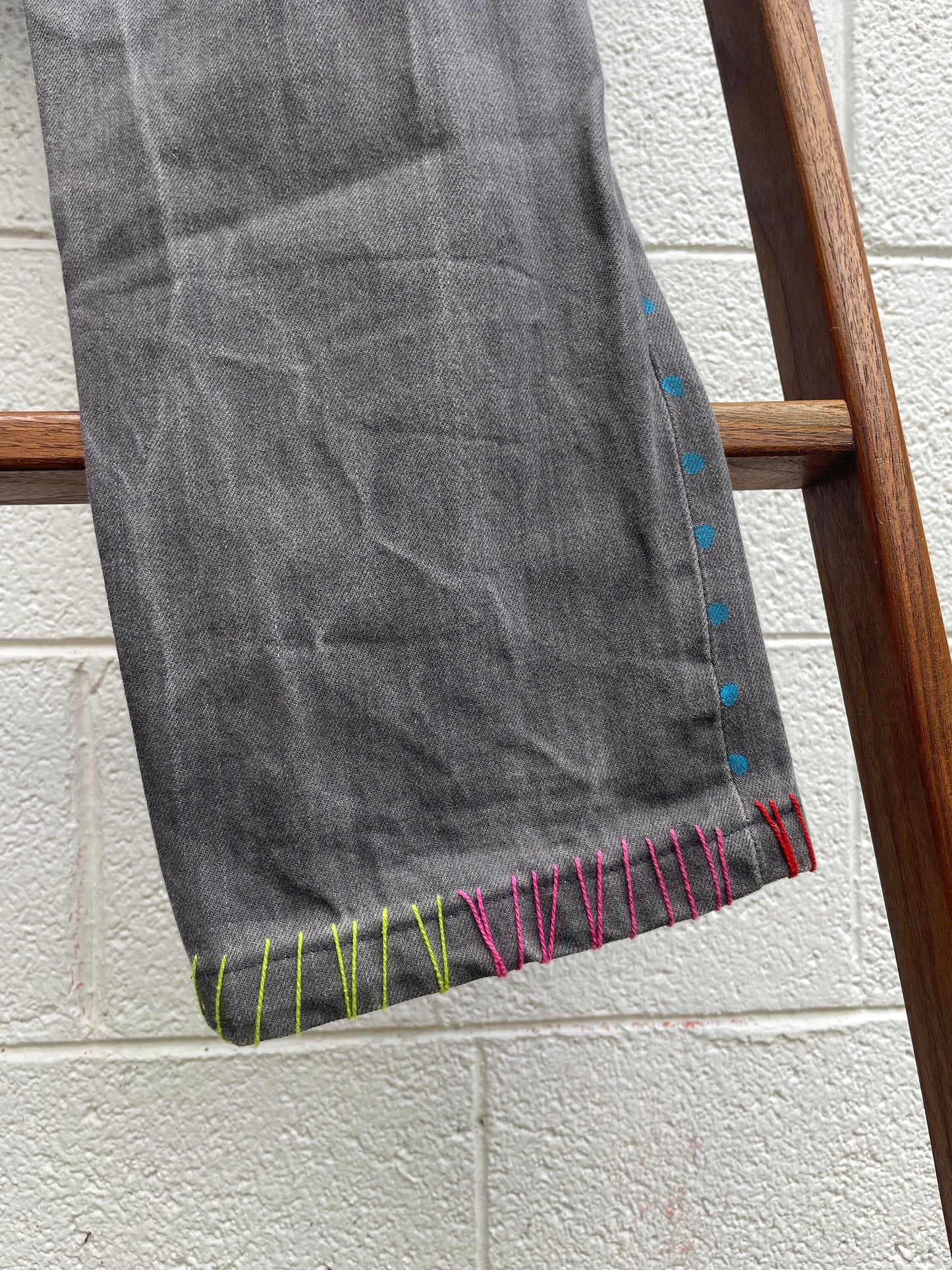Tripp's Store : Bespoke one of a kind embroidered hand stitched patched gray jeans // Unisex Sizes 32 X 31 // Grey boho painted jeans